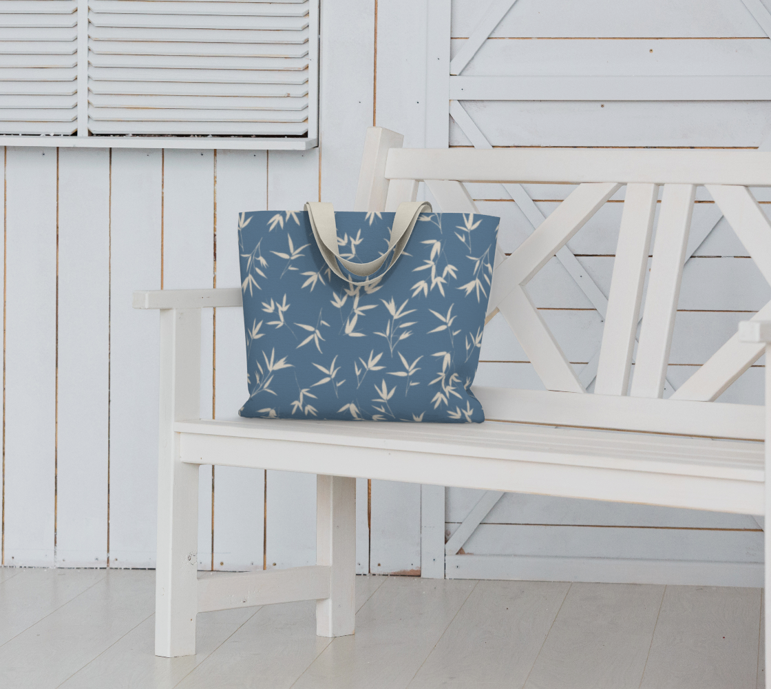 denim blue with bone coloured bamboo leaves market tote bag placed on a white bench seat