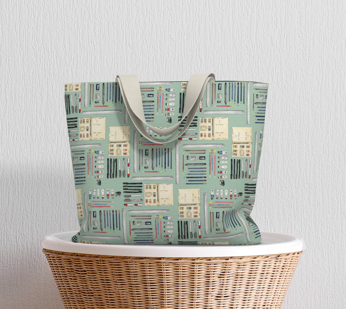 Art Supplies in a repeating pattern on a sage green background. Large market tote bag with white cotton canvas handles.