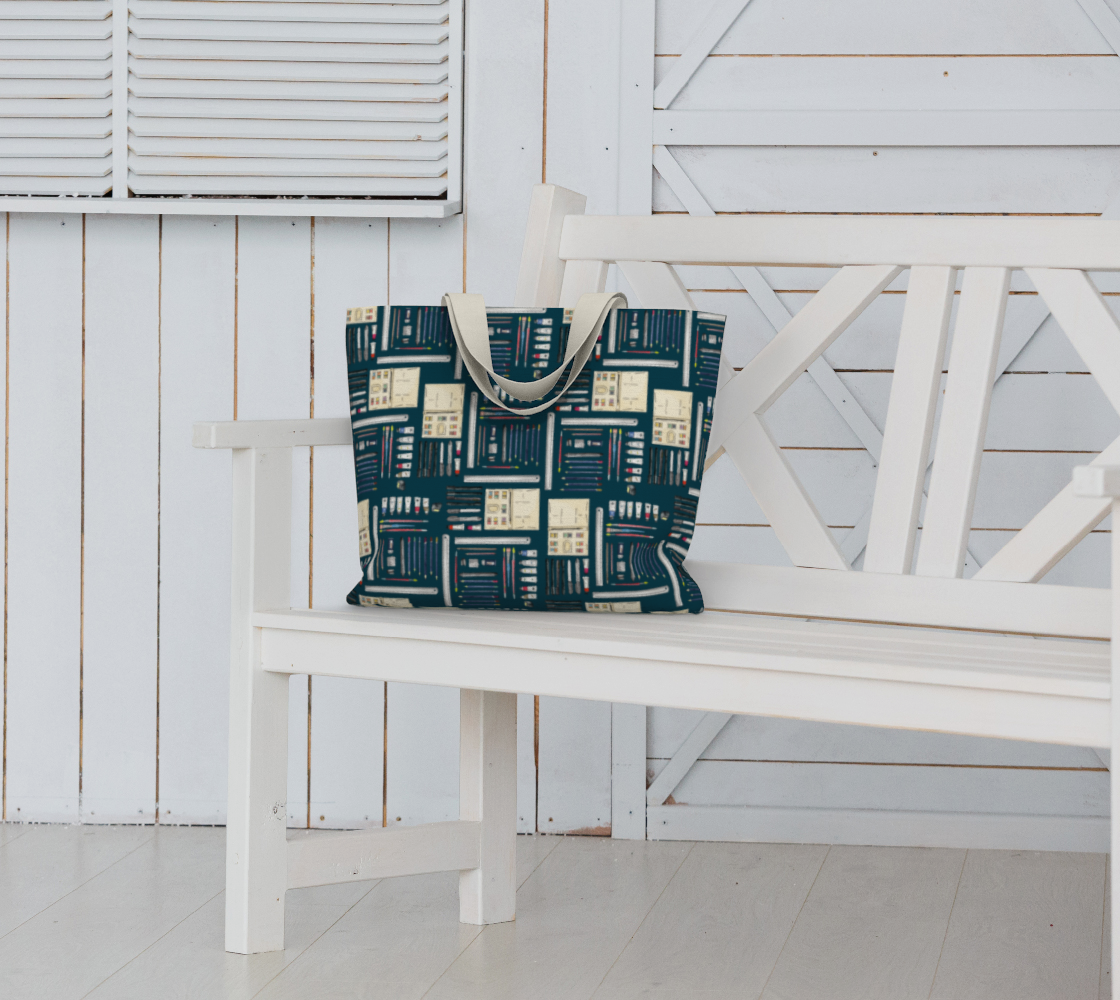 Art Supplies in a repeating pattern on a Dark Teal background. Large market tote bag with white cotton canvas handle.  Bag sitting on a white garden bench seat.