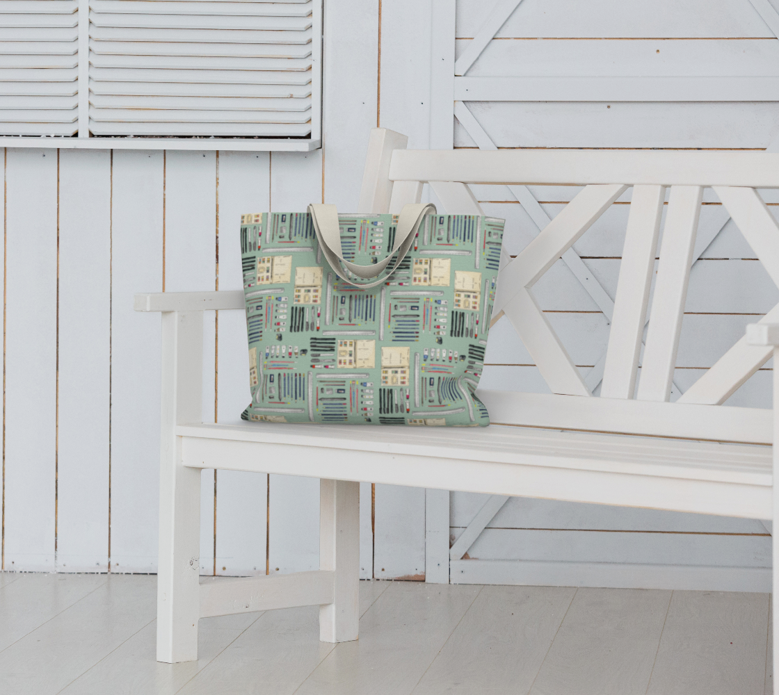 Art Supplies in a repeating pattern on a sage green background. Large market tote bag with white cotton canvas handles.